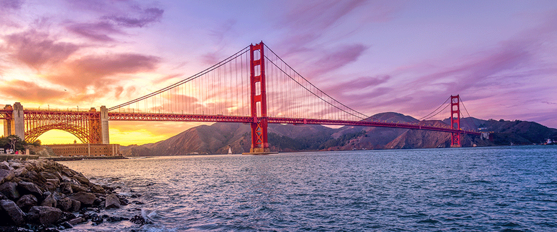 San Francisco's Golden Gate Bridge, with a purple and gold sunset sky