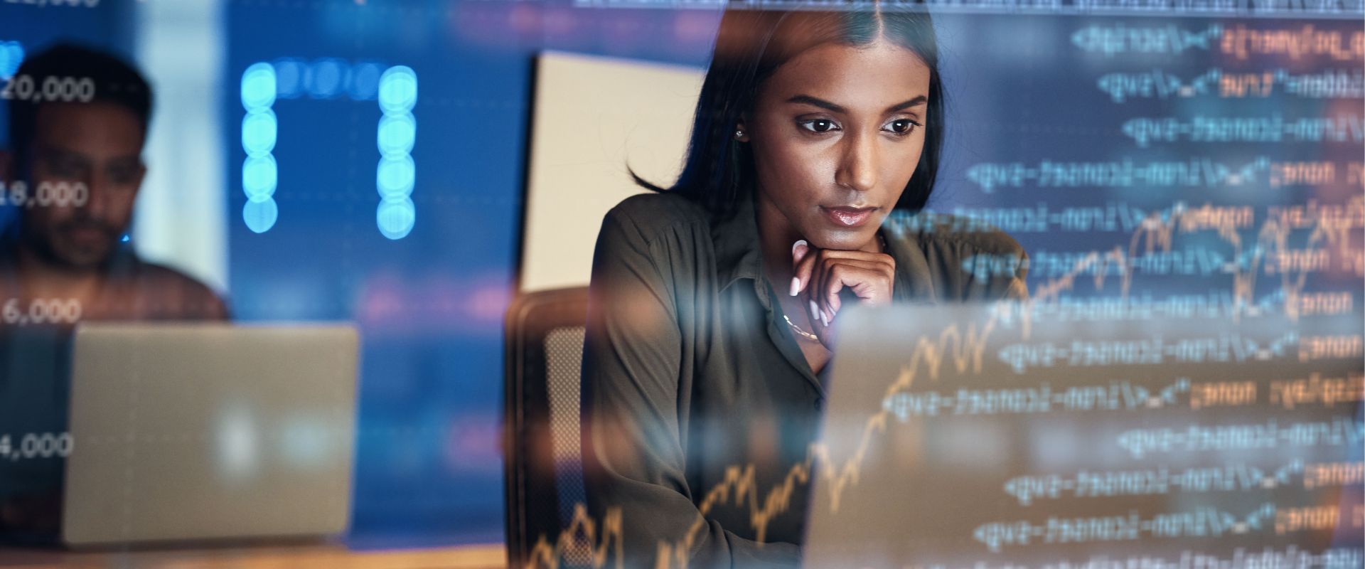 Woman immersed in business analytics. Code is superimposed.