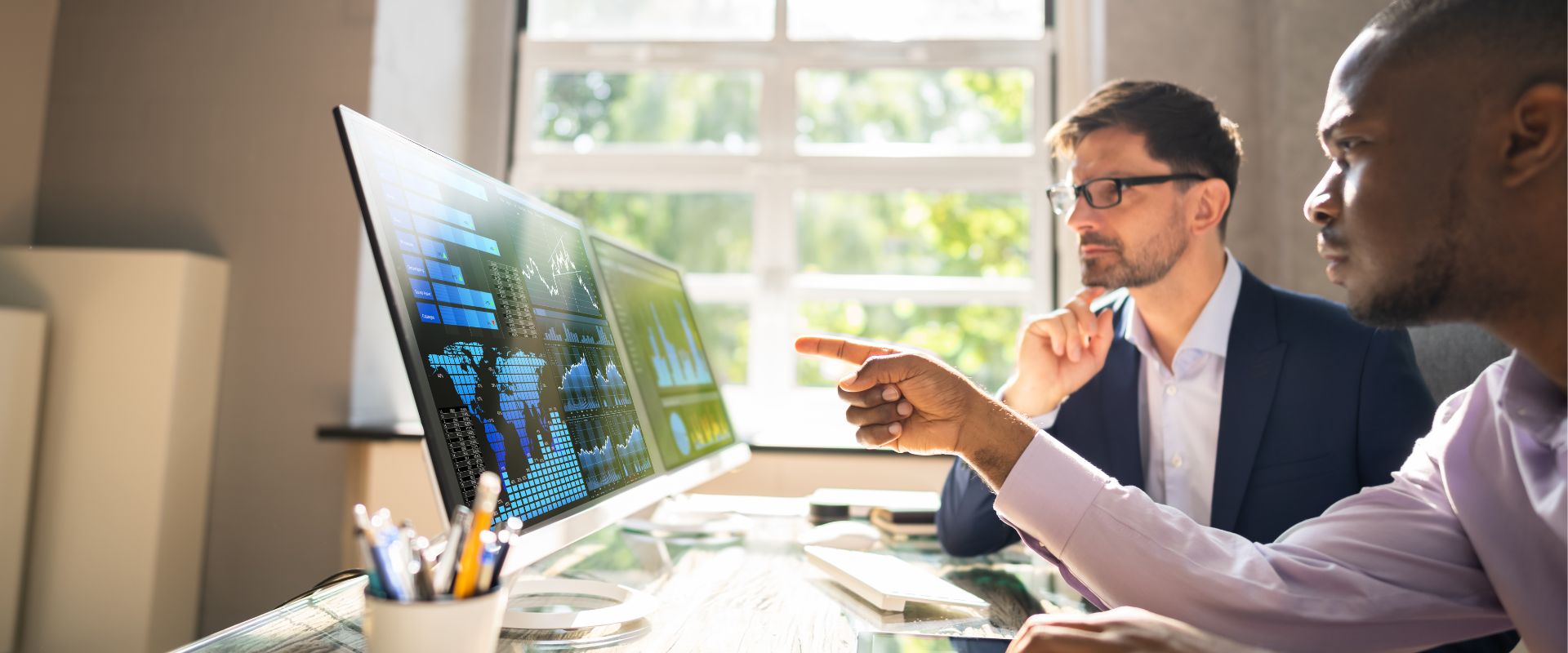 Two men explore business analytics at a desk