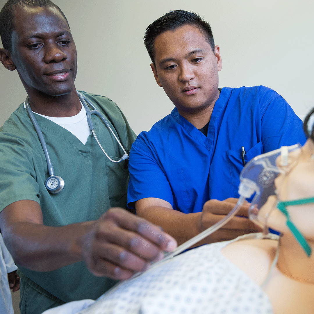 Two students in CMA class practice administering oxygen