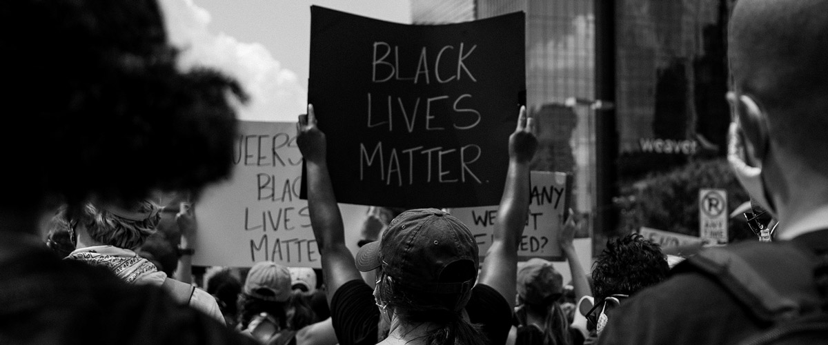 Black and white photo of protest with sign reading "Back Lives Matter"