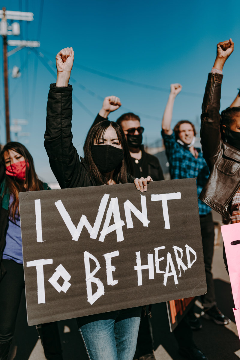 Protester holds up fist and a sign that says "I want to be heard"