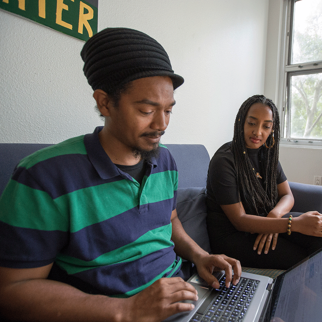 Ethnic Studies teacher on a laptop, with a friend nearby