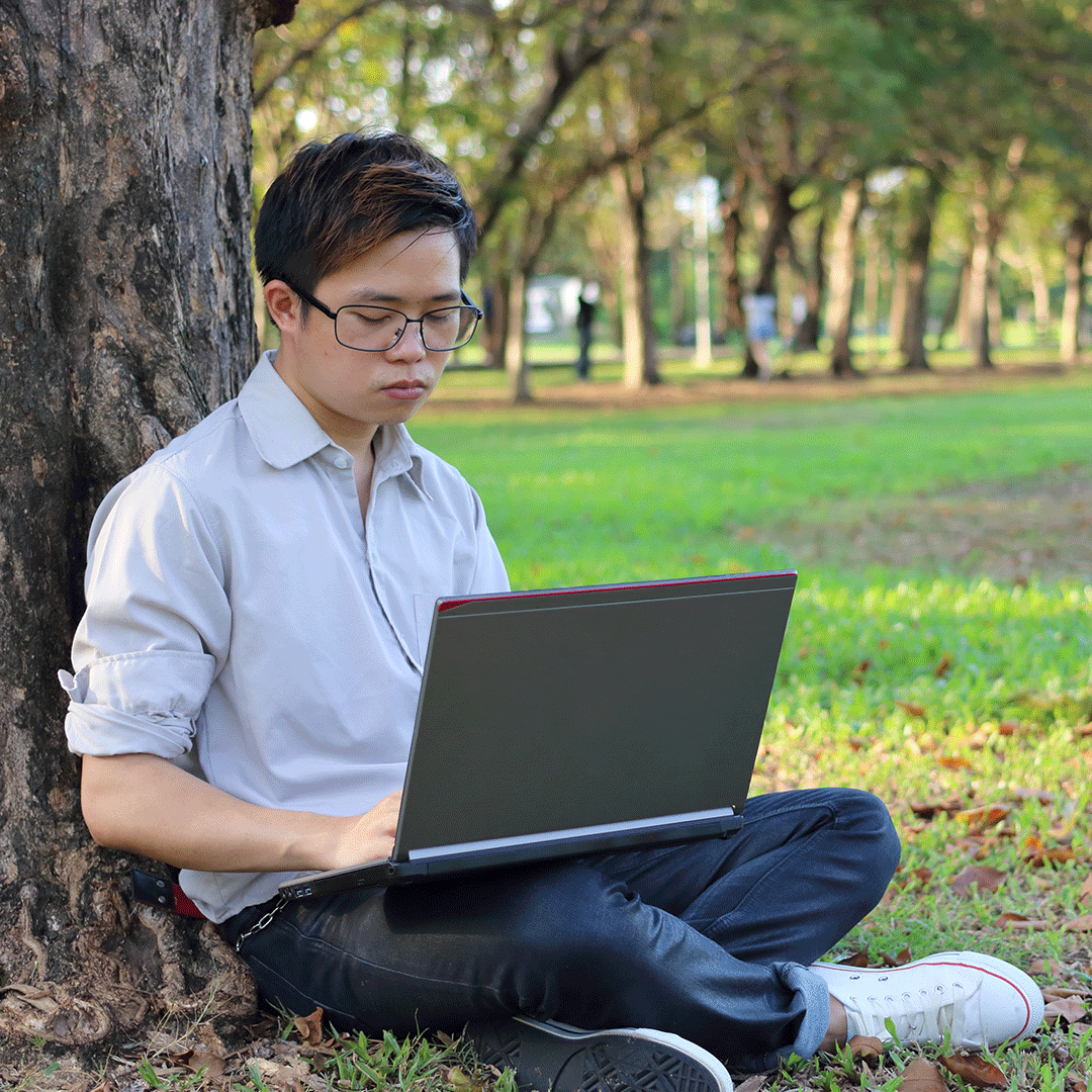 Student takes online class outside under a tree