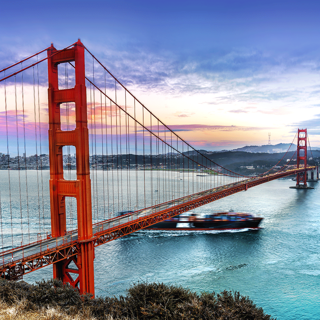 Ship under the Golden Gate Bridge, with a dramatic sunset sky