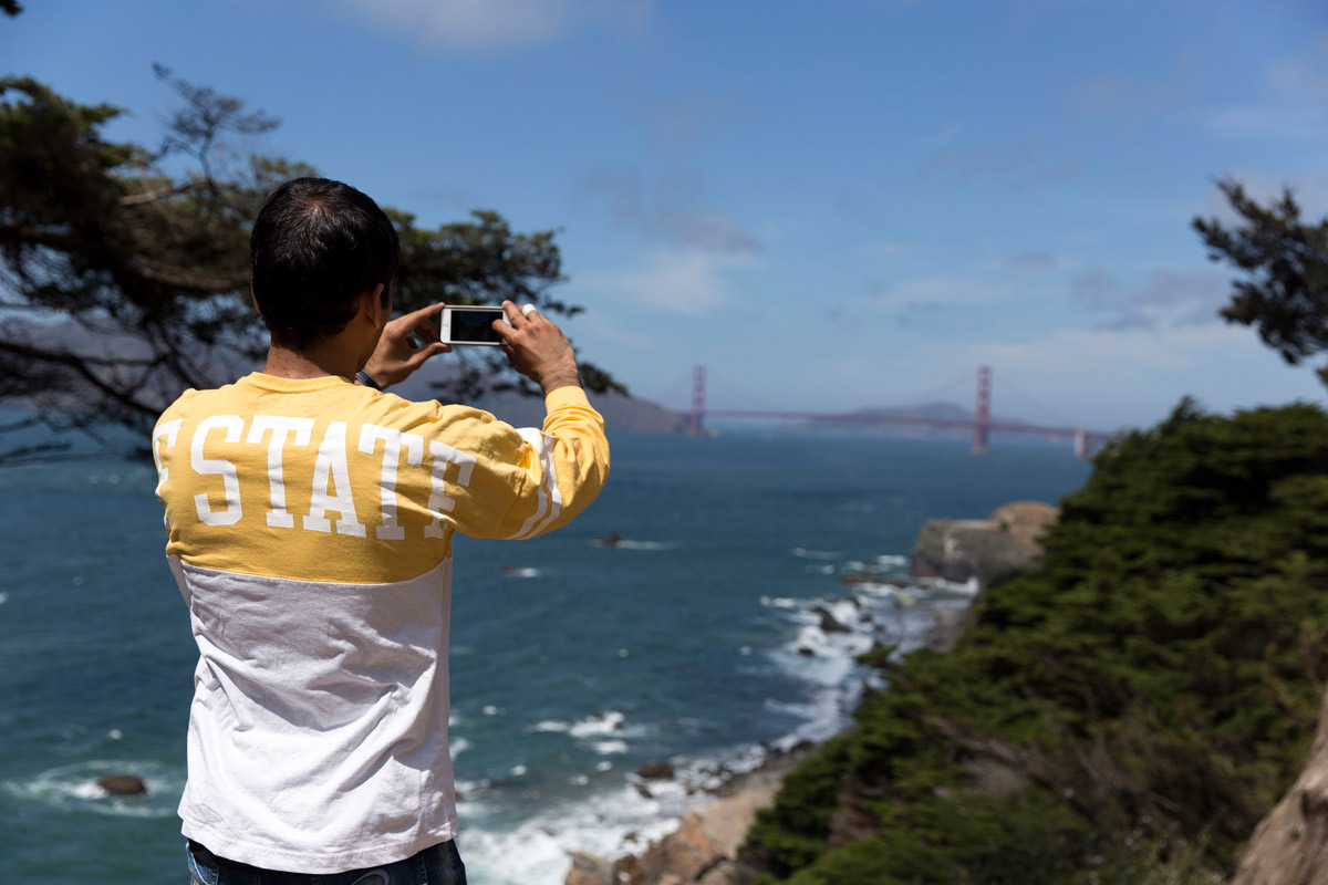 International student takes a photo of the Golden Gate Bridge and the water