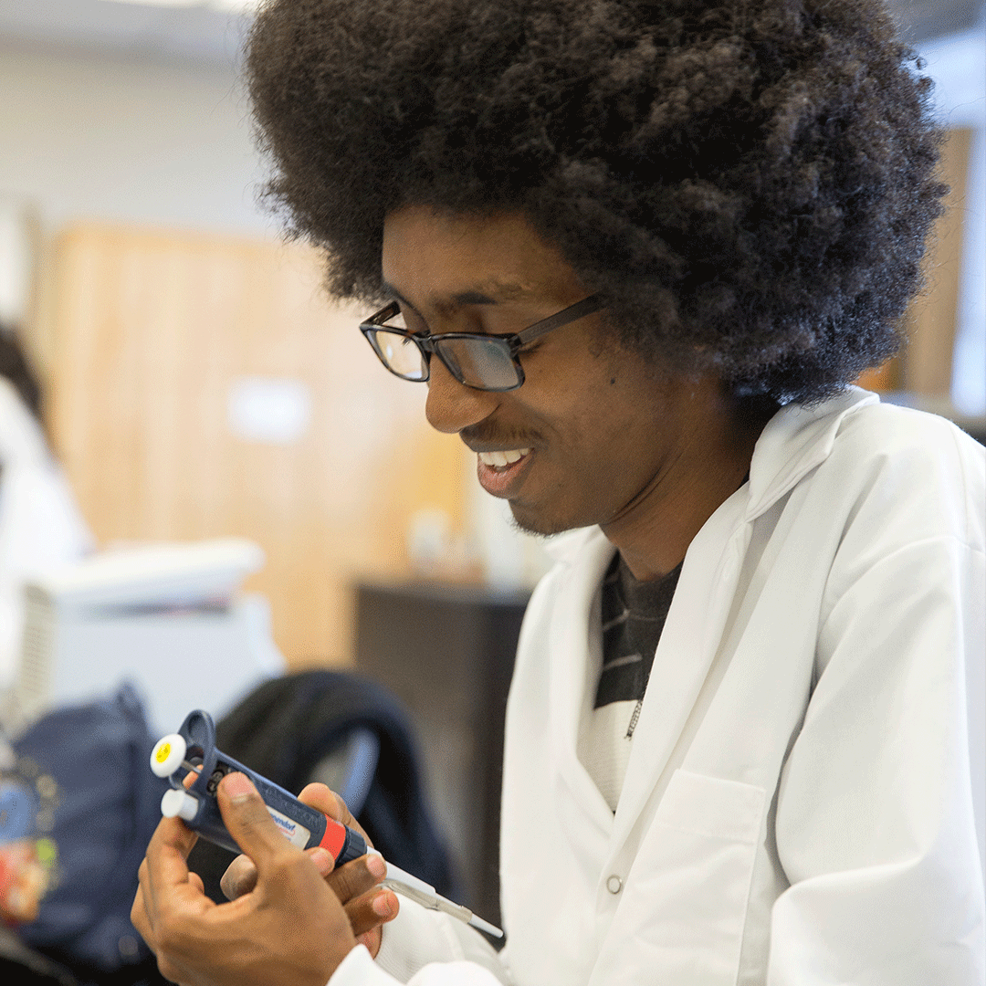 Student smiles while working in the lab