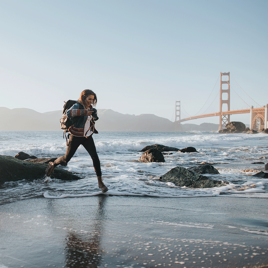 International student on a beach, with the Golden Gate Bridge in the background