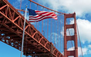 USA flag in front of the Golden Gate Bridge