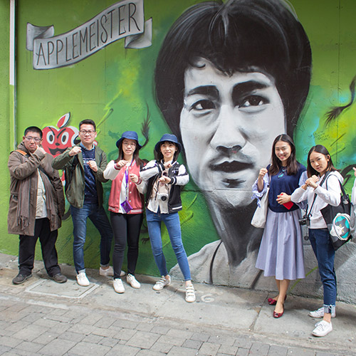 International students pose at the Bruce Lee mural.