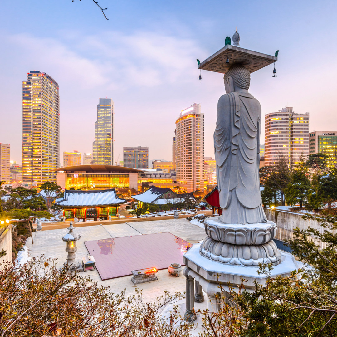 A statue, plaza and buildings at sunset in South Korea