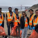International student cleanup volunteers on a foggy beach with the Golden Gate  Bridge behind them in the distance