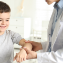 Kid having his arm examined by a school nurse