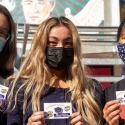 Three students in masks show their Gator Fest cards