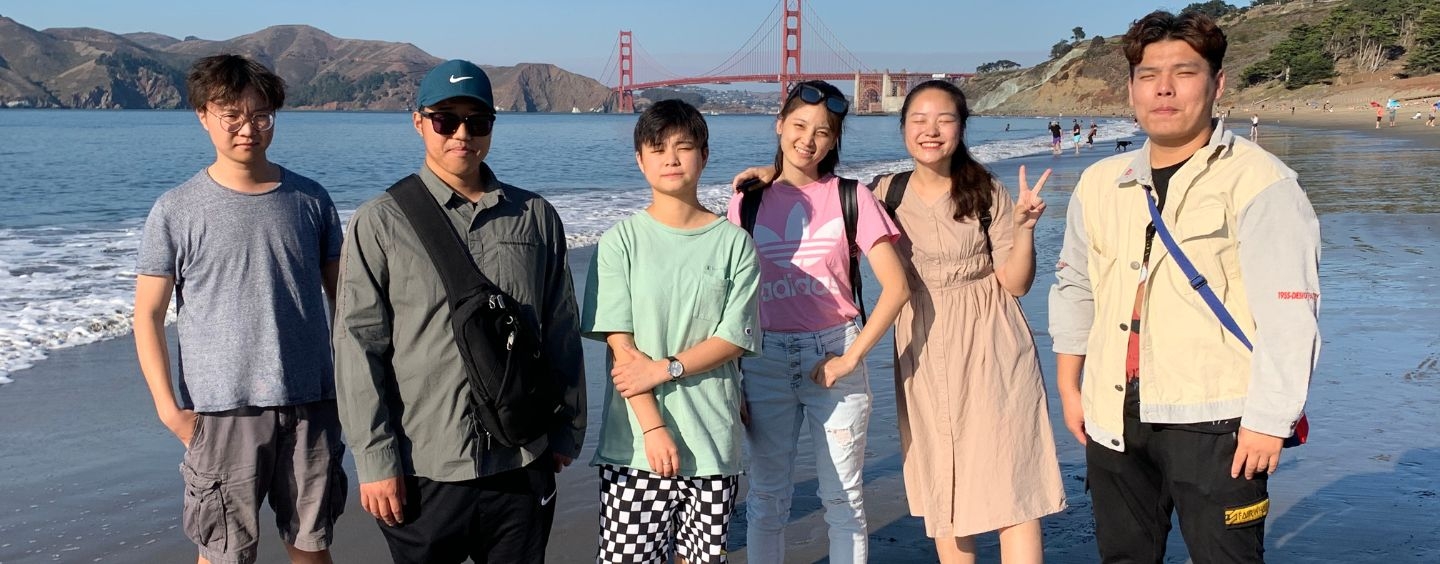 International students on the beach with the Golden Gate Bridge behind them