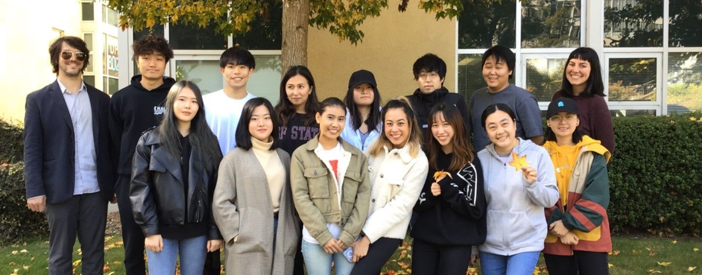 A group of students under a fall tree on campus