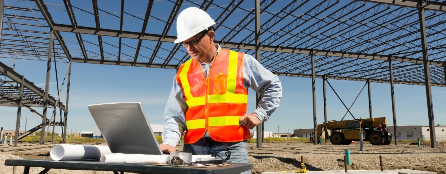 Construction project manager works on his laptop at the job site