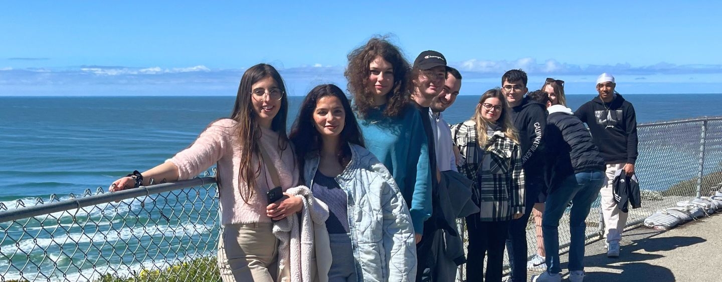 International students on a cliff above the ocean