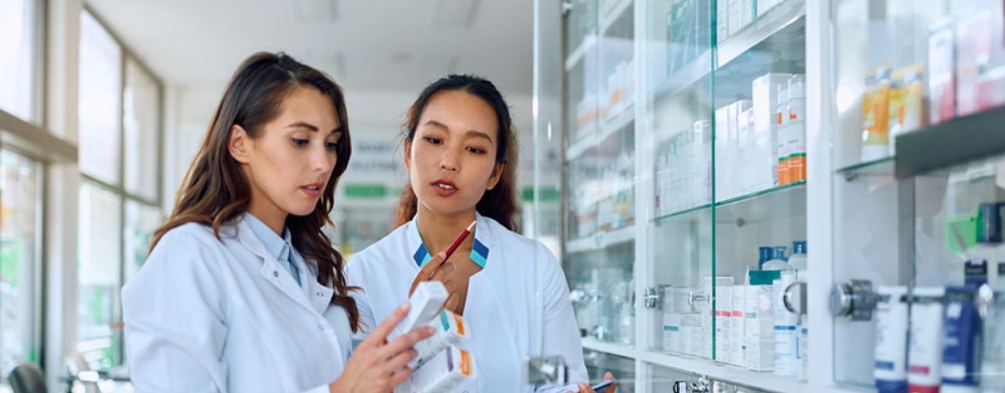 Two pharmacists read medication bottle