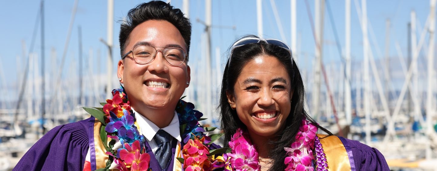 SF State graduates in leis and regalia at a marina