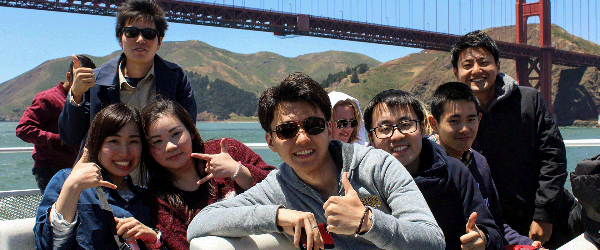 International students on a bay cruise with the Golden Gate Bridge behind them