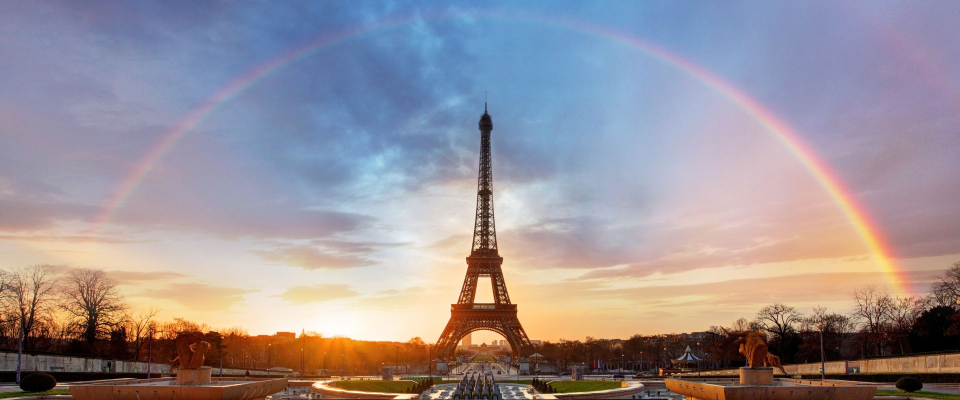 A rainbow over the Eiffel Tower in Paris, with a dramatic pink moment sky