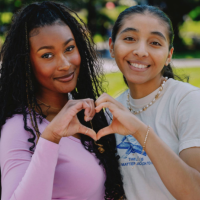 two women on campus make a heart with their hands for SFSU Gator Giving Day