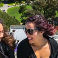 Two students with wind in their hair at the top of the steps above the Student Center