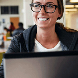 Student smiles while studying on laptop