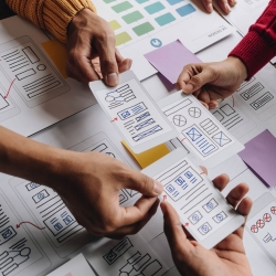 UX Designers hold paper mock-ups