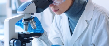 Scientist looking into a microscope in a lab