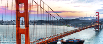 Golden Gate Bridge with a dramatic sky and a ship passing below
