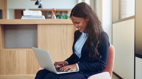 Smiling professional woman uses laptop