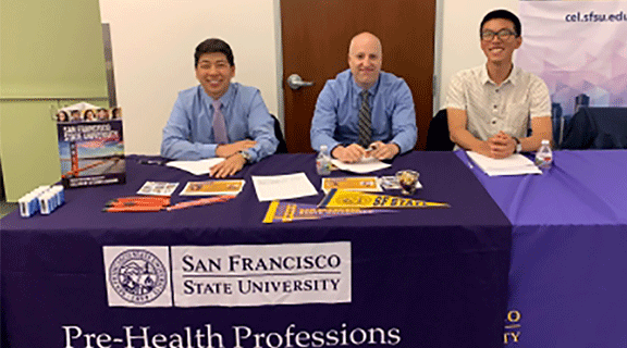 Three staff at table during event