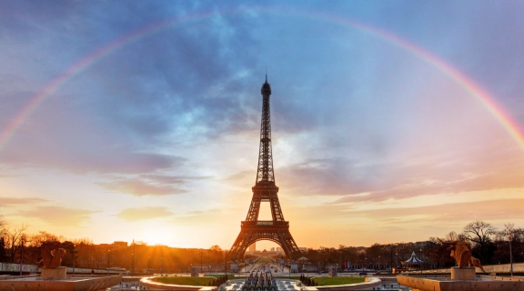 A rainbow over the Eiffel Tower in Paris, with a dramatic pink moment sky