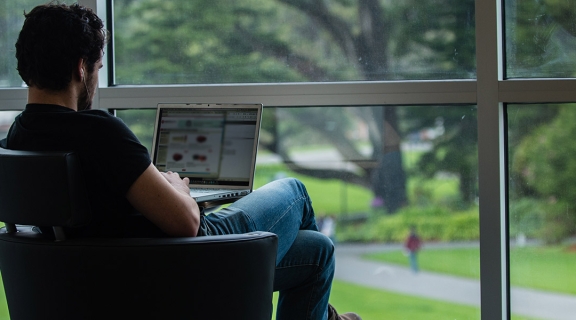 Student takes online course in the library window